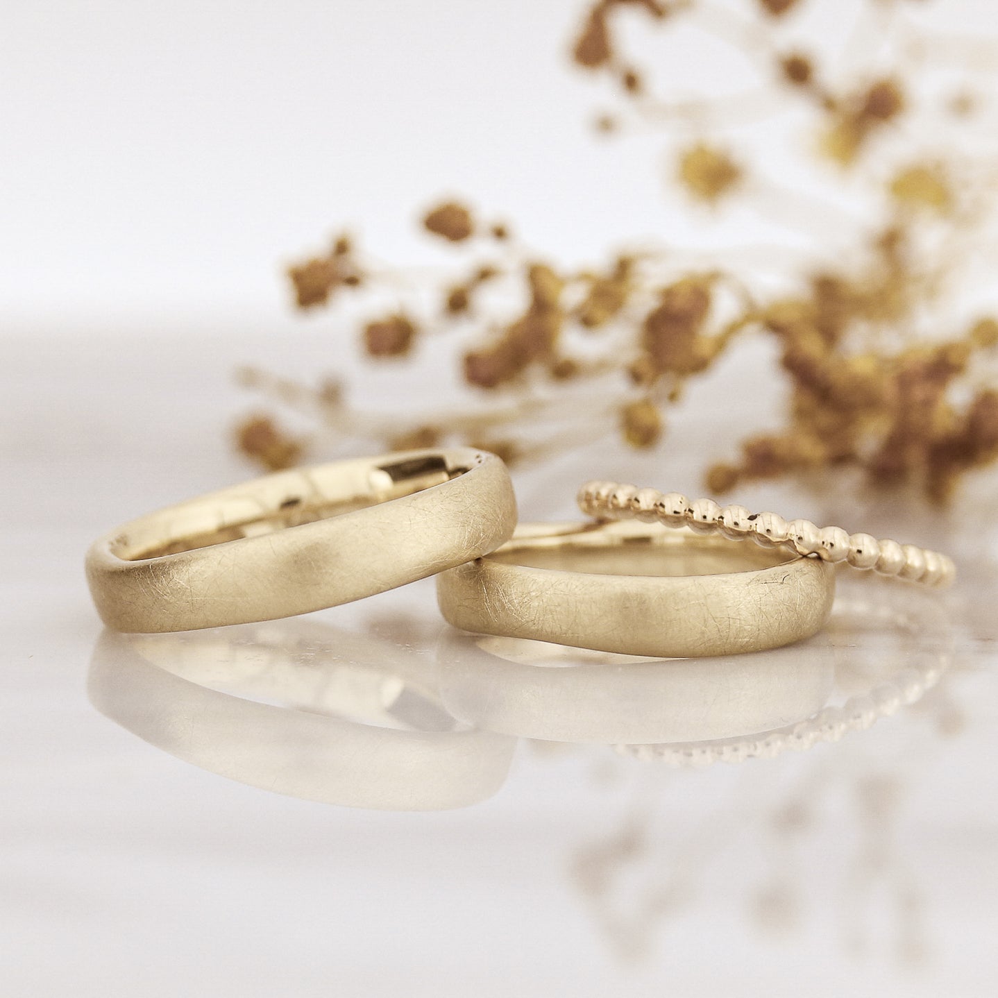 Organische, unregelmäßige Trauringe. Handgefertigt in Goldschmiede in Sankt Ingbert, Saarland. Eheringe im Set mit Kügelchenring.