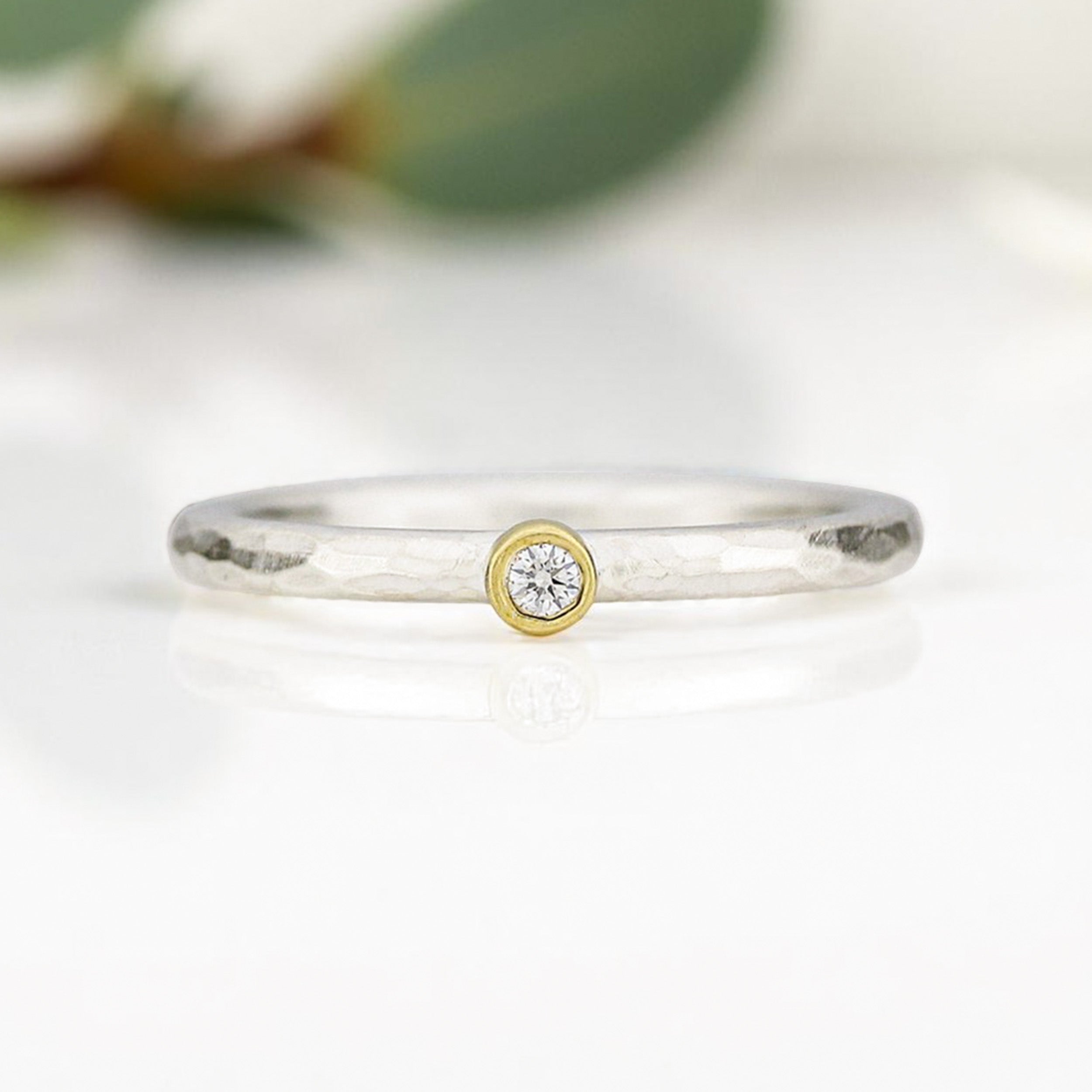 Silberring mit Goldfassung und kleinem Diamant. Geschmiedete Ringschiene.