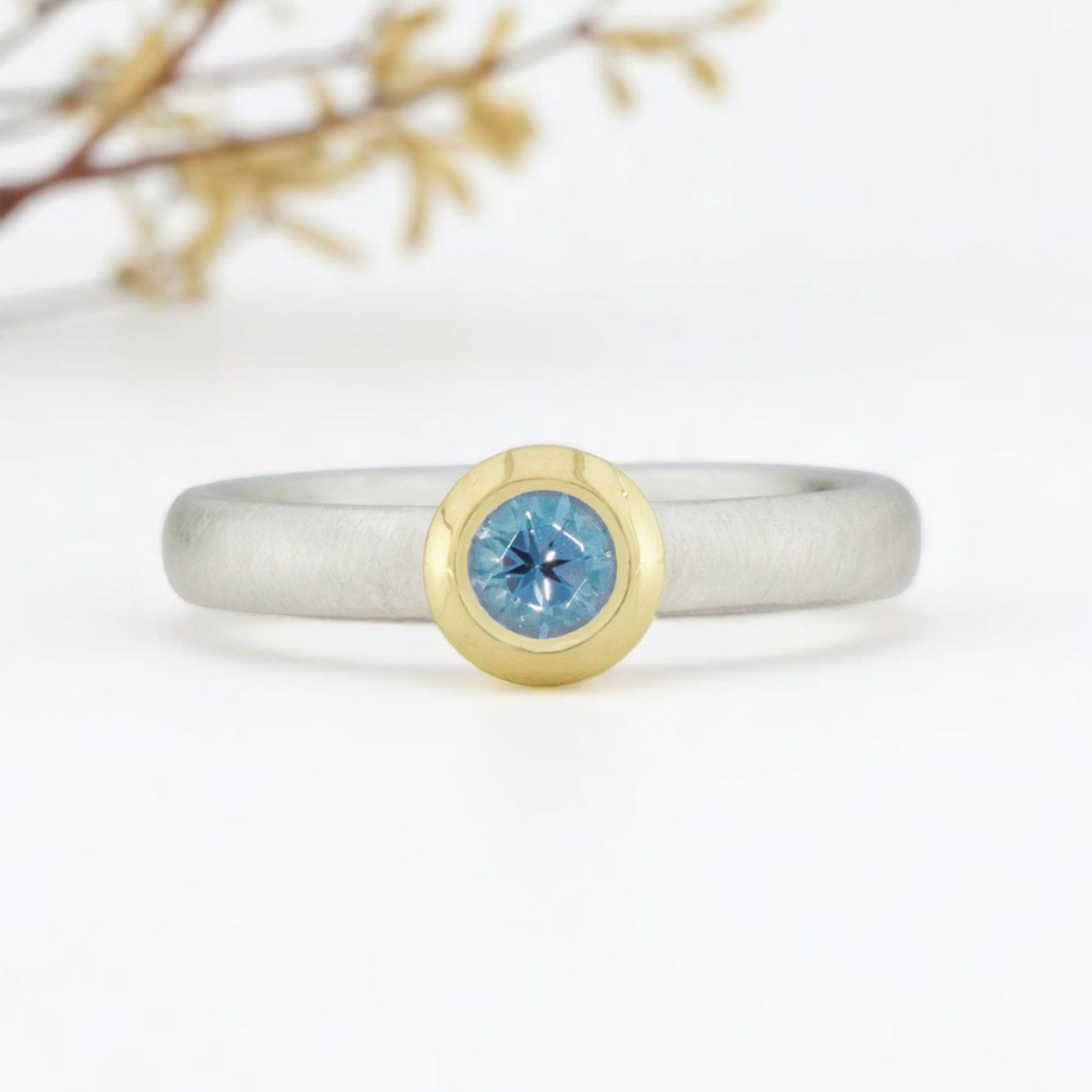 Silberring mit blauem Topas, gefasst in Goldfassung. 