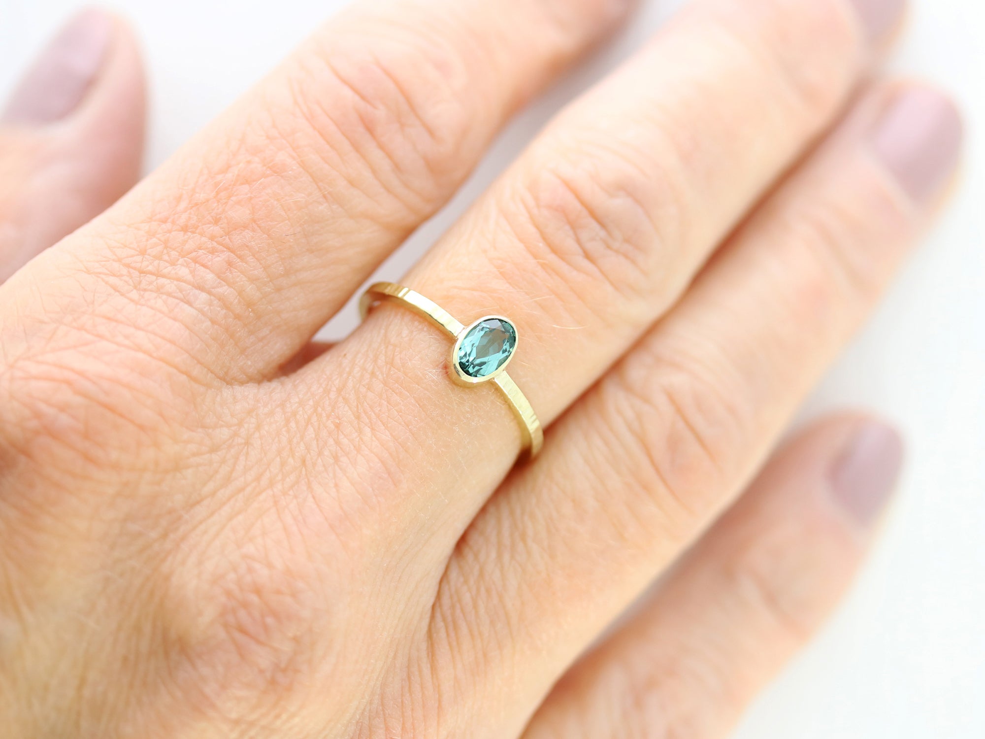 Goldring, geschmiedet mit grünem Turmalin. Gelbgold 585/000. Ovaler, grüner Edelstein.